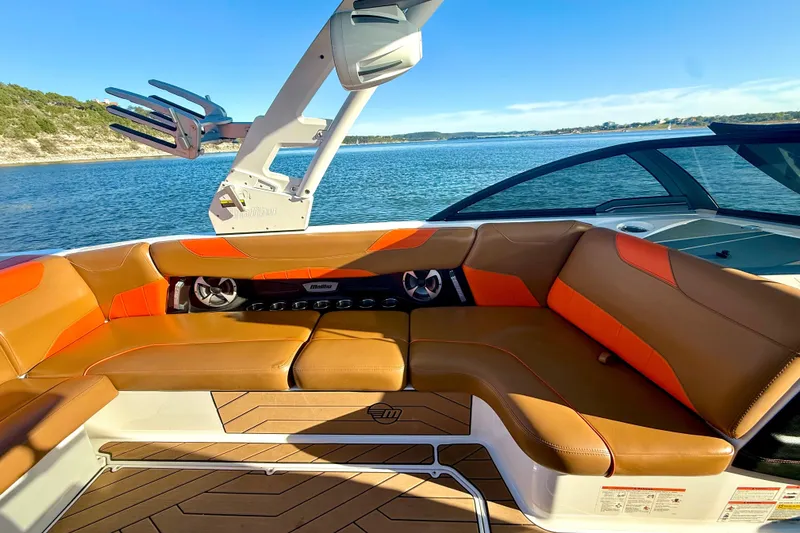 Slide: The Image of 2019 Malibu Wakesetter 23 LSV boat interior with tan and orange seating, lake view. - 46