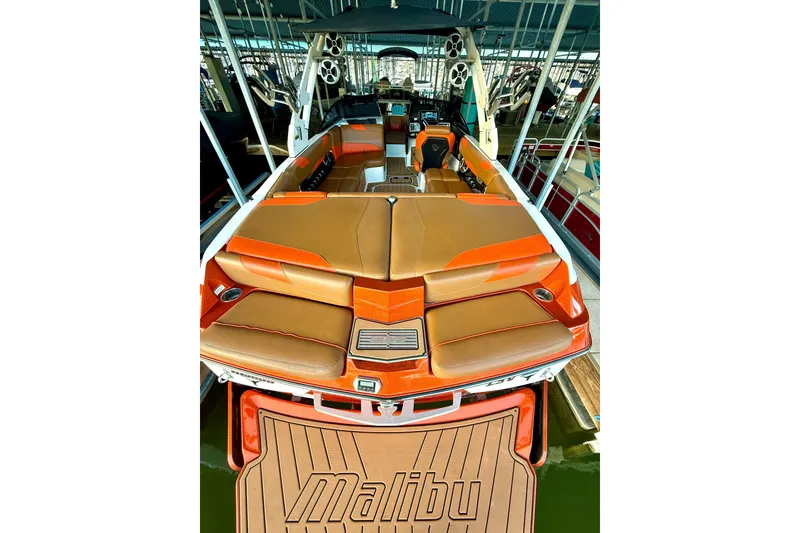 Slide: The Image of 2019 Malibu Wakesetter 23 LSV boat with orange and tan seating, docked in a marina. - 63
