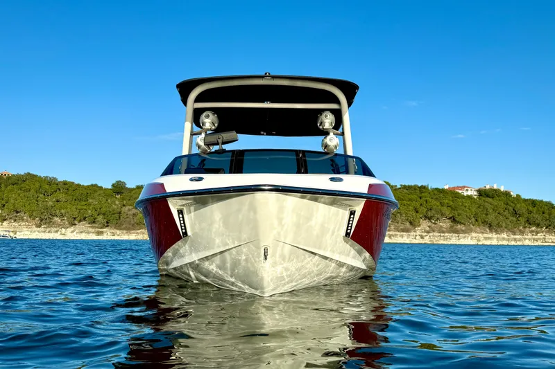 Slide: The Image of 2019 Malibu Wakesetter 23 LSV boat on calm water, clear blue sky. - 8