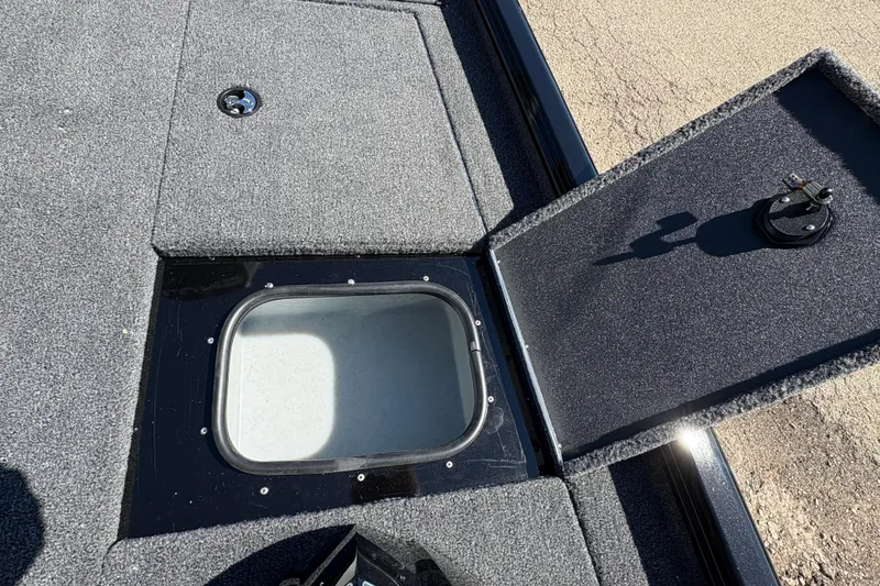 Slide: The Image of 2026 Lund 1875 Renegade boat storage compartment with open hatch, showcasing interior space. - 11