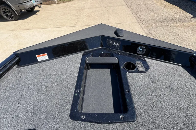 Slide: The Image of 2026 Lund 1875 Renegade boat deck with storage compartment and control panel. - 13