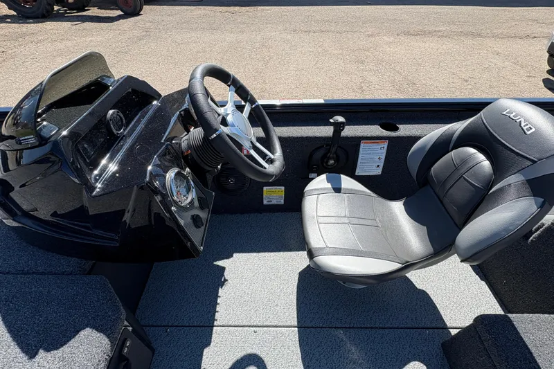 Slide: The Image of 2026 Lund 1875 Renegade boat interior with steering wheel and comfortable seating. - 15