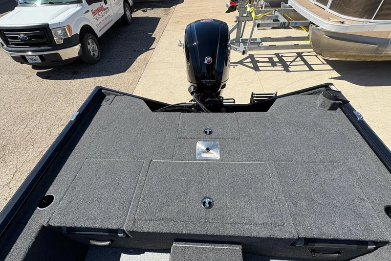 Slide: The Image of 2026 Lund 1875 Renegade boat with motor, parked near a truck and trailer. - 21