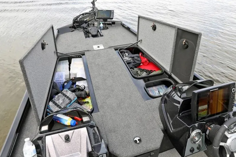 Slide: The Image of Manufacturer Provided Image: 2025 Lund 1875 Renegade boat interior with open storage compartments and fishing gear. - 25