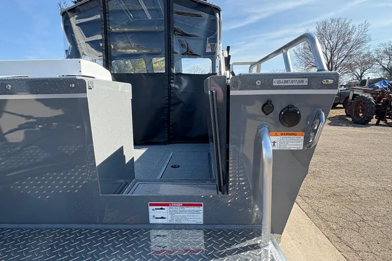 Slide: The Image of 2026 Lund 210 Heavy Gauge boat rear view with metal deck and safety warnings. - 11