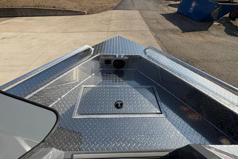 Slide: The Image of 2026 Lund 210 Heavy Gauge boat with diamond plate deck, docked on concrete. - 18