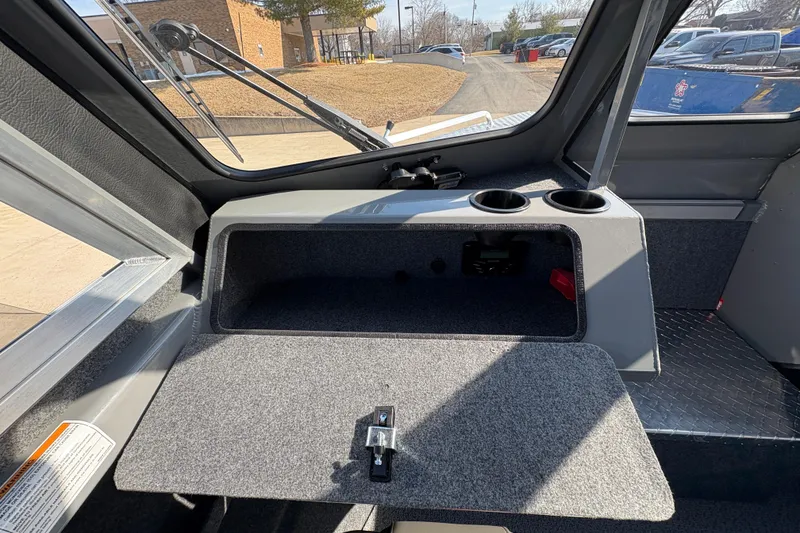 Slide: The Image of Interior of 2026 Lund 210 Heavy Gauge boat with open storage compartment and cup holders. - 22