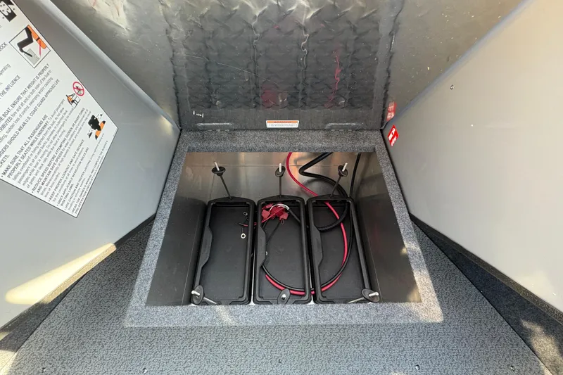 Slide: The Image of 2026 Lund 210 Heavy Gauge boat battery compartment with wiring and safety instructions. - 26