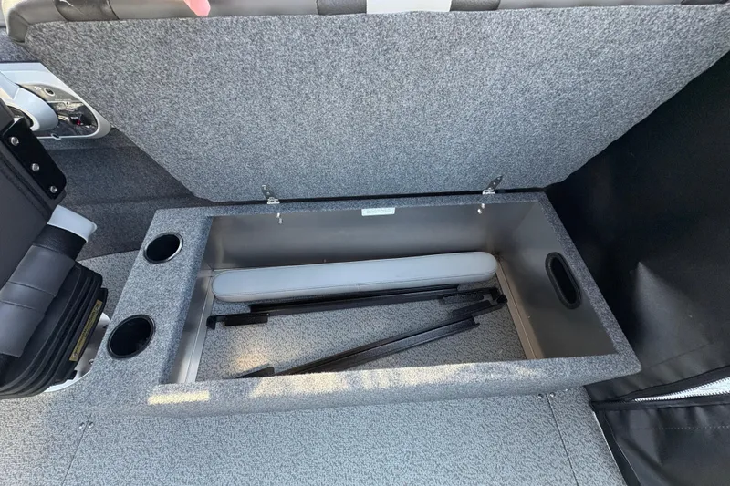 Slide: The Image of Open storage compartment in 2026 Lund 210 Heavy Gauge boat, featuring cup holders and gray interior. - 34