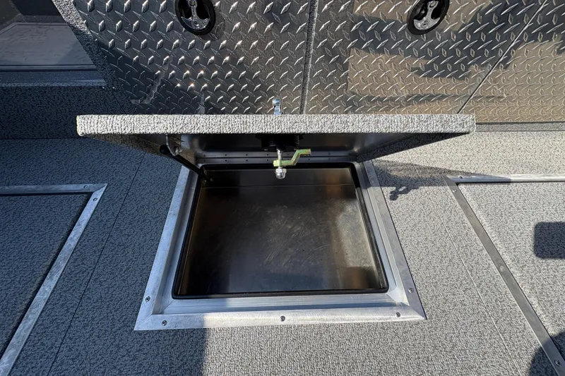 Slide: The Image of Open storage compartment on 2026 Lund 210 Heavy Gauge boat, featuring diamond plate design. - 41