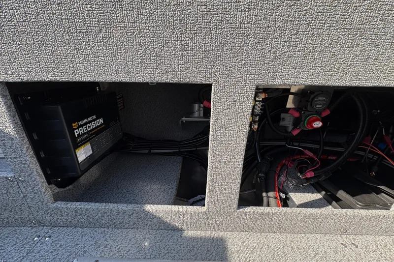 Slide: The Image of 2026 Lund 210 Heavy Gauge boat electrical compartment with Minn Kota Precision charger. - 42