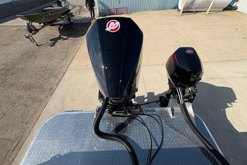 Slide: The Image of 2026 Lund 210 Heavy Gauge boat with dual outboard motors on a metal platform. - 50