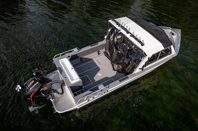 Slide: The Image of Manufacturer Provided Image: 2025 Lund 210 Heavy Gauge boat on water, featuring spacious deck and powerful outboard motor. - 57