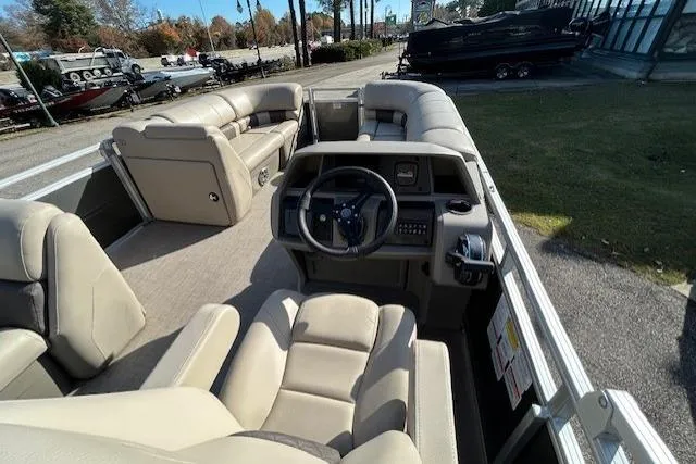 Slide: The Image of 2025 Sun Tracker Party Barge 20 DLX interior with plush seating and steering console. - 8