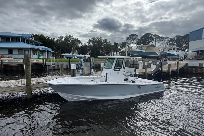 Slide: The Image of 2026 Blackfin 262 HB boat docked at a marina under cloudy skies. - 39