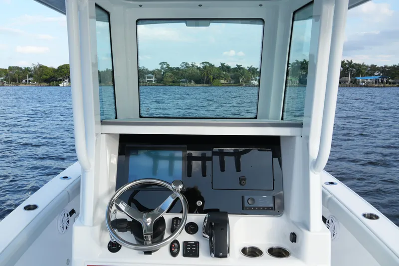 Slide: The Image of 2026 Blackfin 262 HB boat helm with steering wheel and control panel on open water. - 56