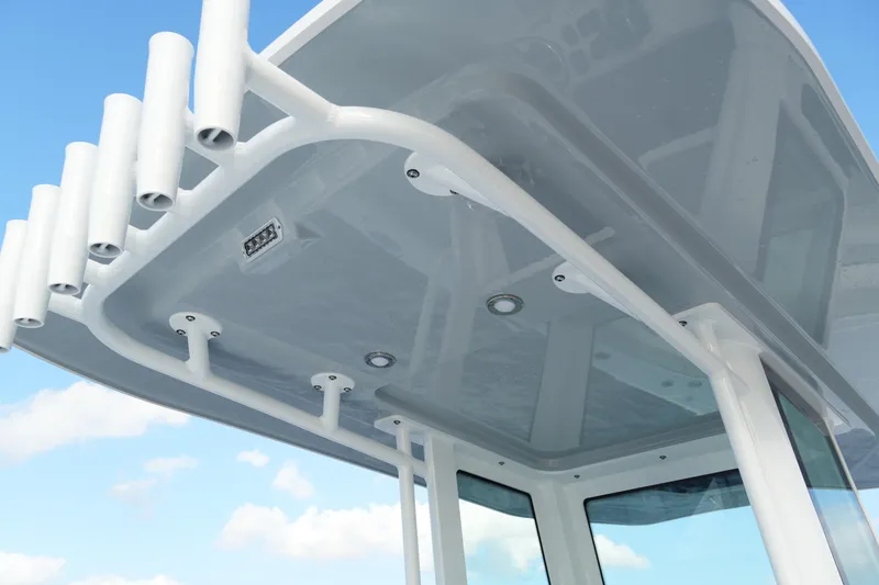 Slide: The Image of 2026 Blackfin 262 HB boat roof with rod holders against blue sky. - 58