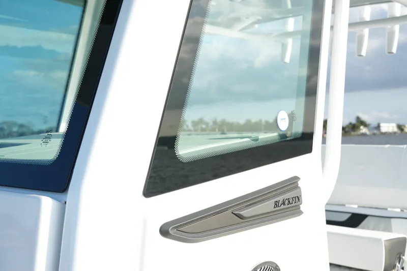Slide: The Image of 2026 Blackfin 262 HB boat window detail with logo, against a scenic water backdrop. - 73