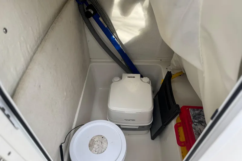 Slide: The Image of Storage compartment of 2019 Sea Hunt Ultra 235 SE boat with portable toilet and accessories. - 14