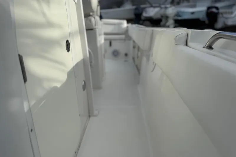 Slide: The Image of 2019 Sea Hunt Ultra 235 SE boat interior with white seating and storage compartments. - 15