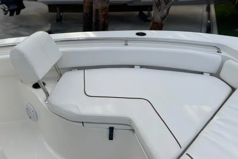 Slide: The Image of 2019 Sea Hunt Ultra 235 SE boat with white cushioned seating and stainless steel rail. - 16