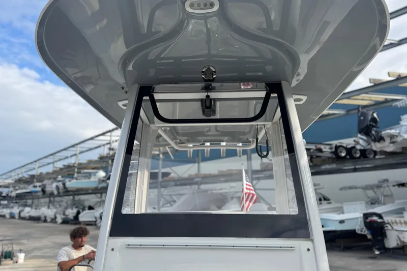 Slide: The Image of 2019 Sea Hunt Ultra 235 SE boat with T-top and American flag in marina. - 18