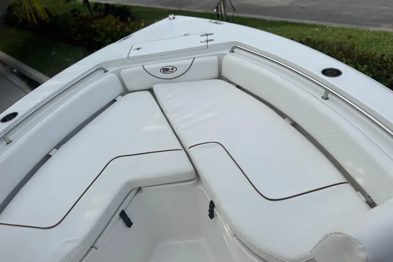 Slide: The Image of 2019 Sea Hunt Ultra 235 SE boat with white cushioned seating area. - 20