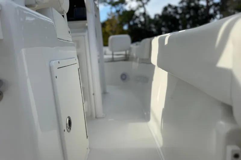 Slide: The Image of 2019 Sea Hunt Ultra 235 SE boat interior, showcasing sleek white design and storage compartment. - 21