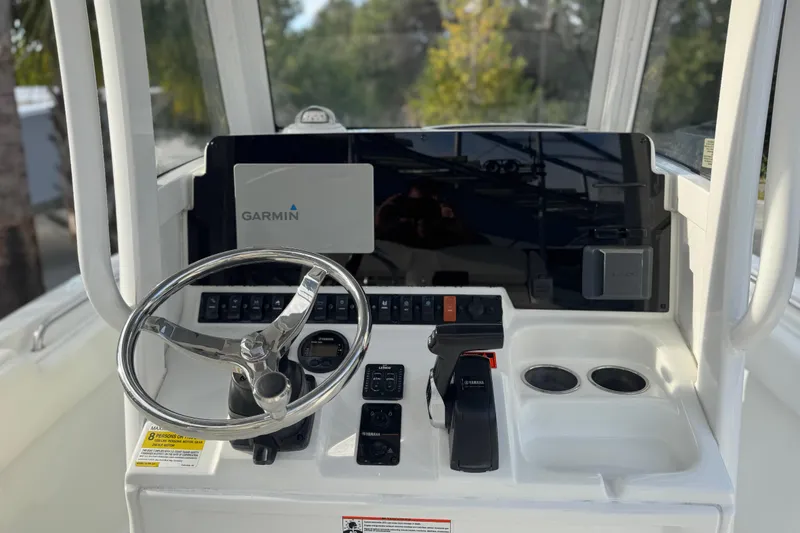 Slide: The Image of 2019 Sea Hunt Ultra 235 SE boat dashboard with Garmin navigation system and steering wheel. - 23