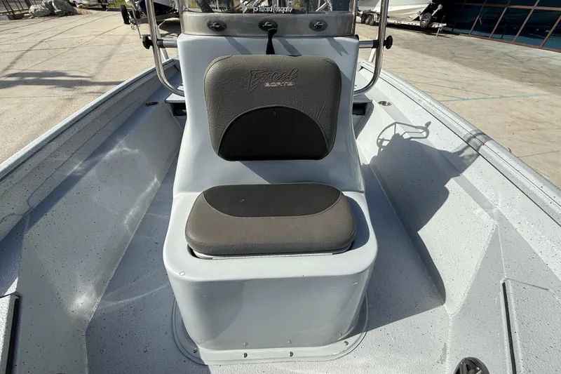 Slide: The Image of 2018 Excel 203 Bay Pro boat with cushioned seating and console, docked outdoors. - 12