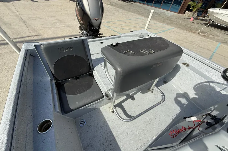 Slide: The Image of 2018 Excel 203 Bay Pro boat interior with seating and motor, docked outdoors. - 13