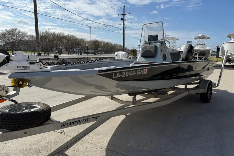 Slide: The Image of 2018 Excel 203 Bay Pro boat on trailer, featuring Minn Kota motor, parked outdoors. - 4