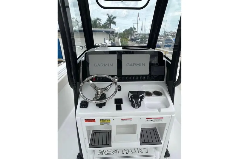 Slide: The Image of 2024 Sea Hunt Gamefish 25 helm with dual Garmin displays and steering wheel. - 6