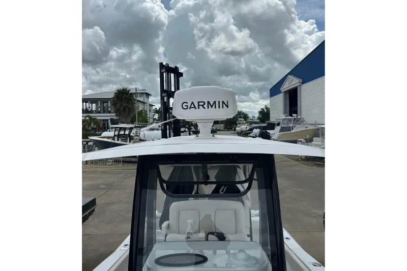 Slide: The Image of 2024 Sea Hunt Gamefish 25 boat with Garmin radar, docked under cloudy skies. - 9
