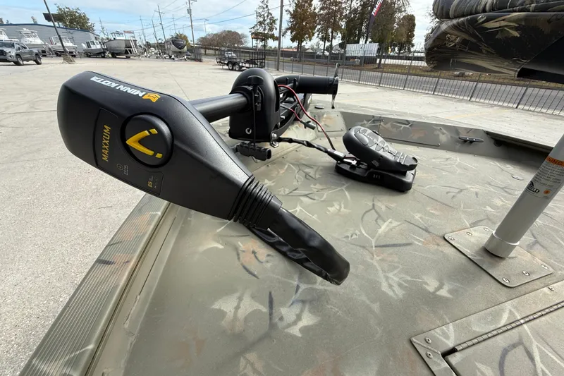 Slide: The Image of 2025 Tracker Grizzly 1754 SC boat with Minn Kota trolling motor on camo deck. - 10