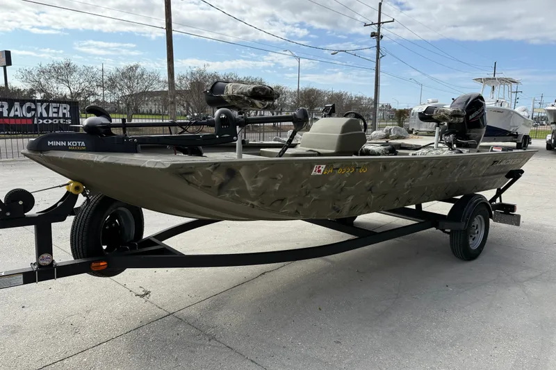 Slide: The Image of 2025 Tracker Grizzly 1754 SC boat on trailer, featuring Minn Kota motor, parked outdoors. - 4