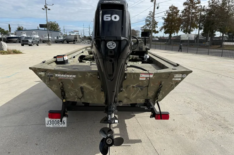 Slide: The Image of 2025 Tracker Grizzly 1754 SC boat with Mercury 60 engine, parked outdoors. - 6