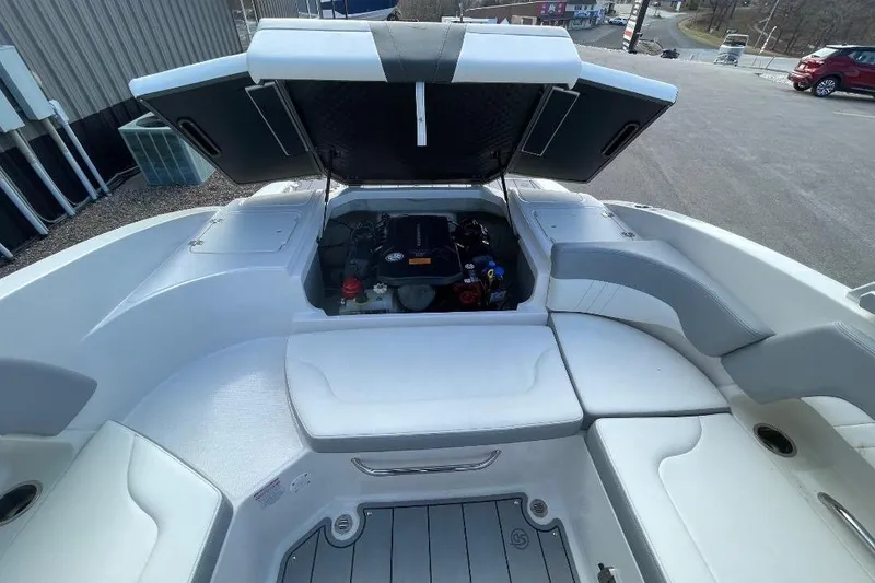 Slide: The Image of 2023 Chaparral 23 SSi boat with open engine compartment, showcasing seating and storage. - 6