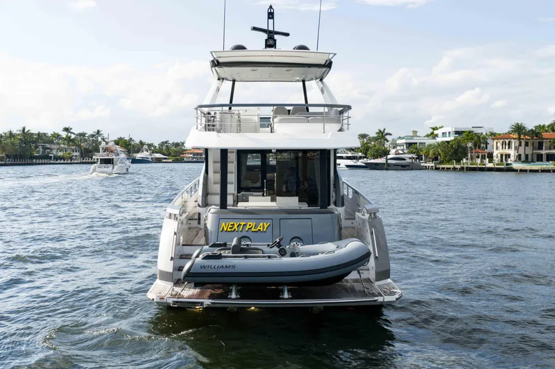 Slide: The Image of 2024 Azimut Fly 68 yacht with tender, cruising in a scenic waterfront setting. - 10