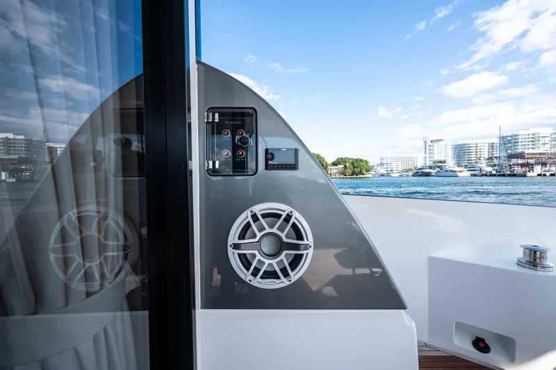 Slide: The Image of 2024 Azimut Fly 68 yacht deck with speaker and control panel, cityscape in background. - 51