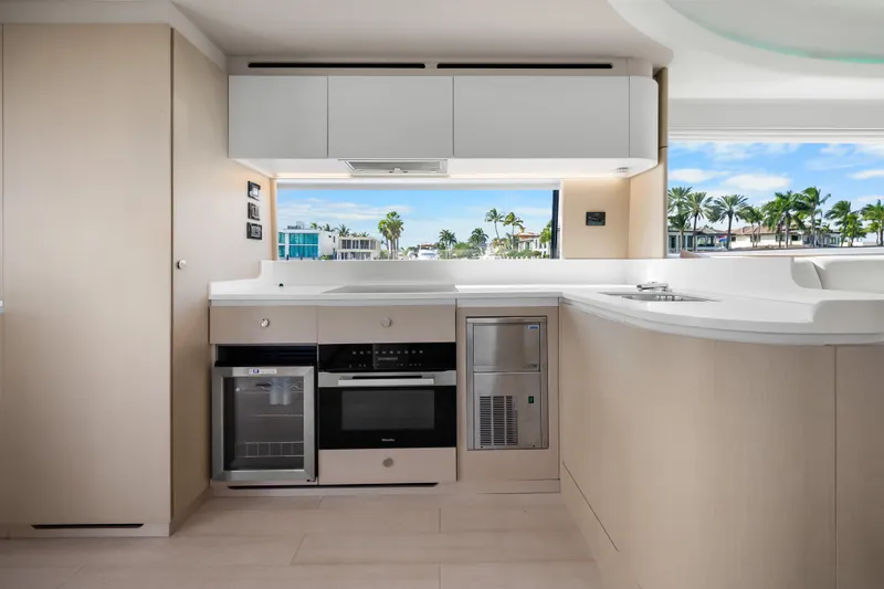Slide: The Image of Modern kitchen interior of 2024 Azimut Fly 68 yacht with appliances and scenic window view. - 69