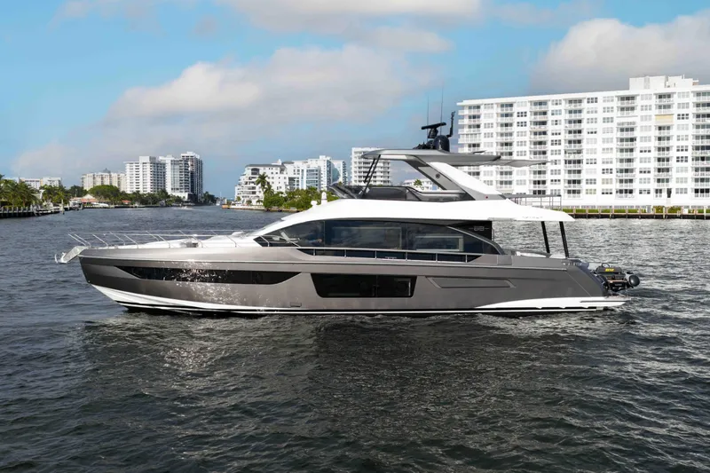 Slide: The Image of 2024 Azimut Fly 68 yacht cruising near modern waterfront buildings. - 7