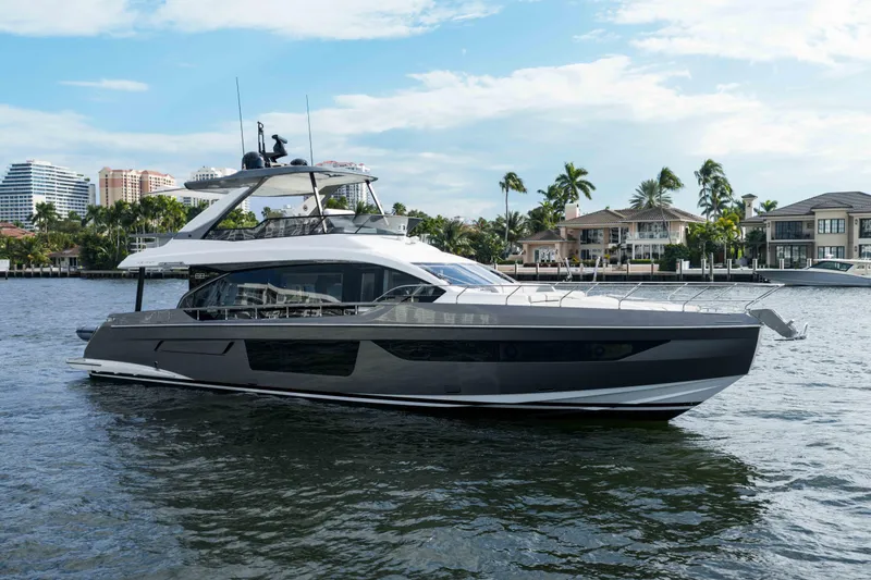 Slide: The Image of 2024 Azimut Fly 68 yacht cruising near waterfront homes under a clear sky. - 9