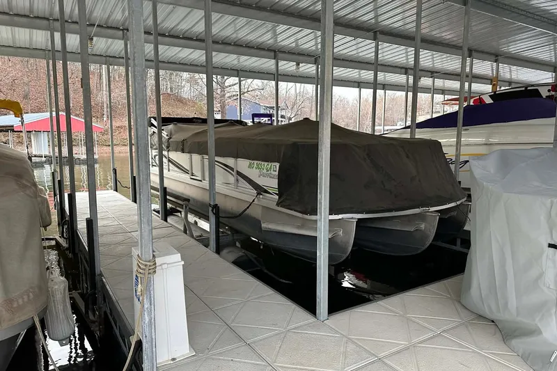 The Image of Covered 2015 PlayCraft 25 Clipper boat docked in a sheltered marina. - 1