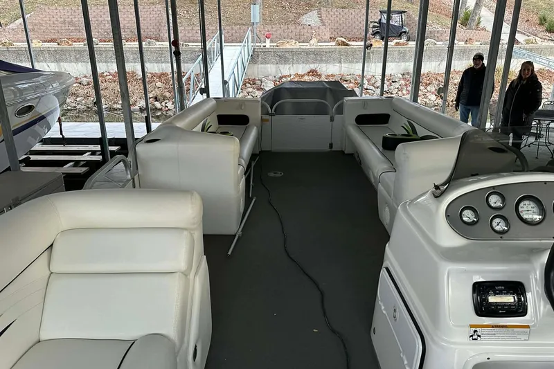 Slide: The Image of 2015 PlayCraft 25 Clipper pontoon boat interior with white seating and control panel. - 19