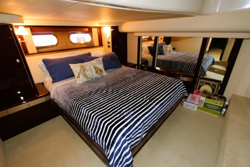 Slide: The Image of Luxurious bedroom interior of 2007 Sea Ray 580 Sedan Bridge yacht with striped bedding. - 12
