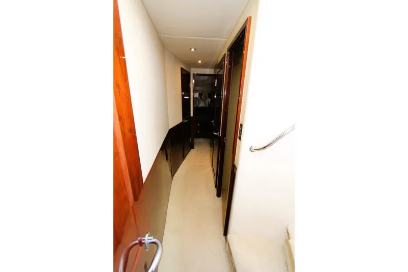 Slide: The Image of Narrow hallway inside 2007 Sea Ray 580 Sedan Bridge yacht with wooden accents. - 16