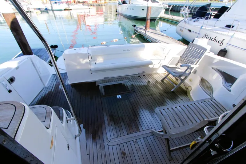 Slide: The Image of 2007 Sea Ray 580 Sedan Bridge yacht deck with seating and wooden flooring. - 26