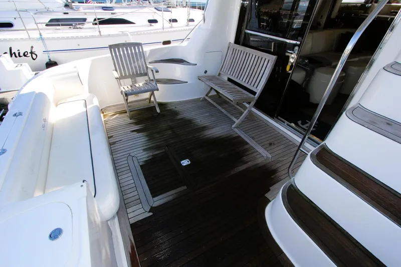 Slide: The Image of 2007 Sea Ray 580 Sedan Bridge yacht deck with seating and wooden flooring. - 27