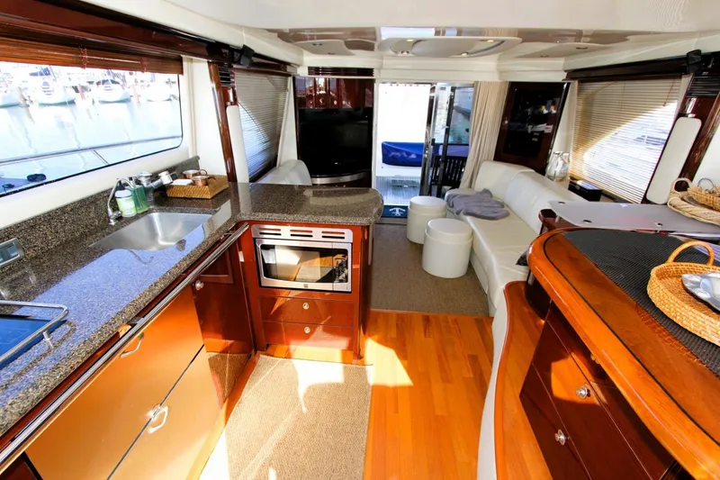 Slide: The Image of Luxurious interior of 2007 Sea Ray 580 Sedan Bridge yacht with modern kitchen and seating area. - 8